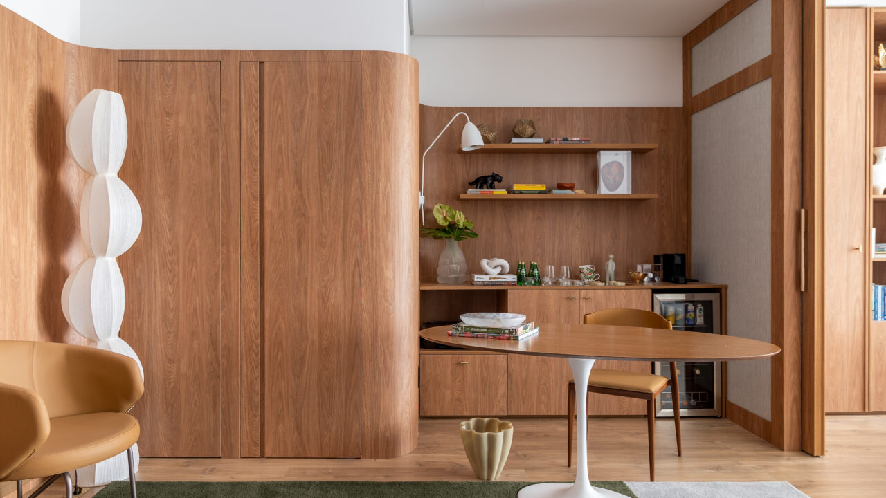 Ana Weege assina consultório psicológico com cara - e aconchego! - de casa. Na foto, sala de espera com luminária, parede curva, mesa e tapete.