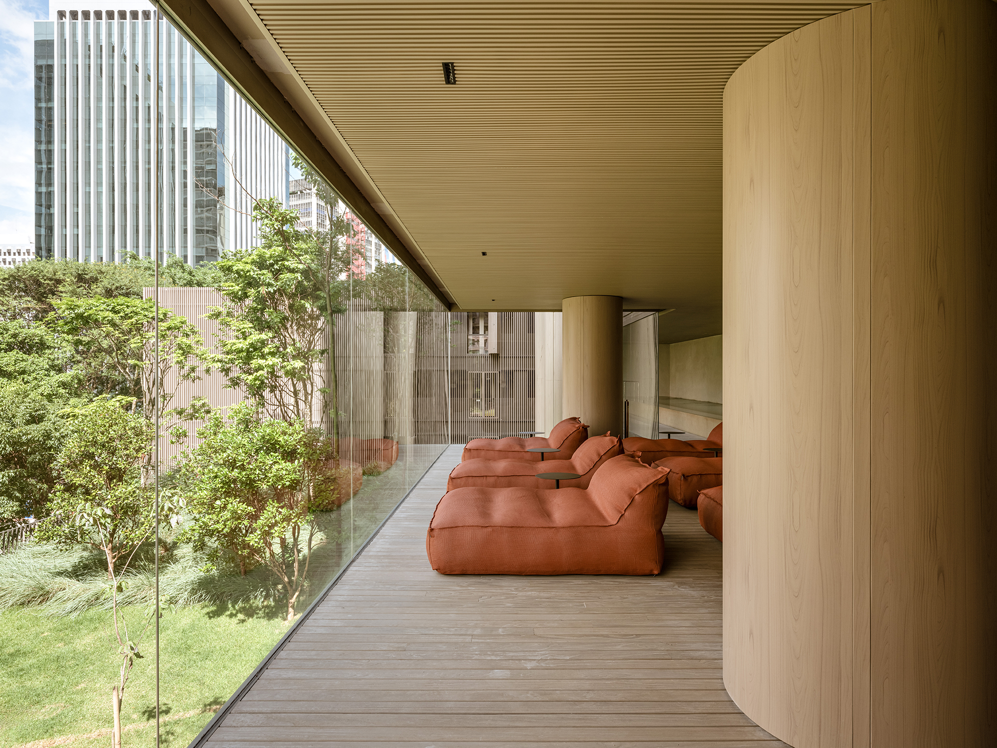 Studio Arthur Casas assina arquitetura e interiores de hotel de luxo em SP. Na foto, área comum com vista para o jardim e poltronas.