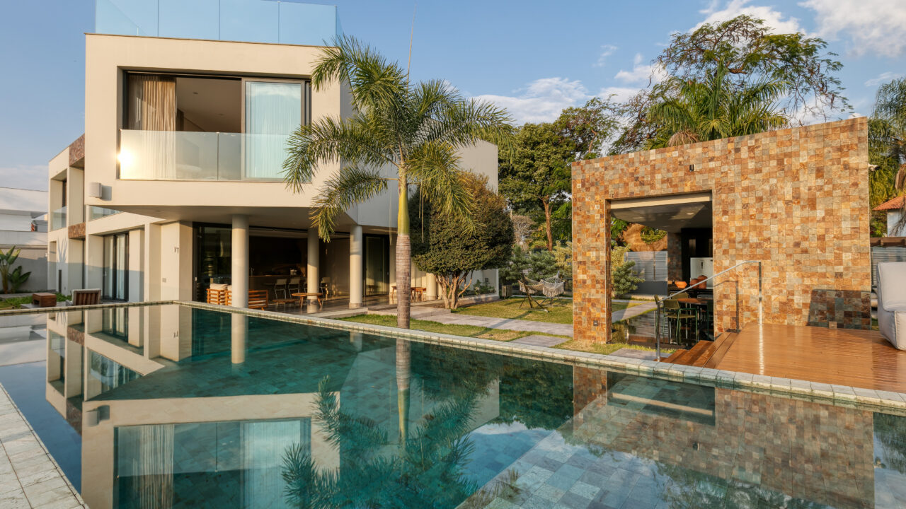 Com vista para a Pampulha, casa de 600 m² é integrada à natureza. Projeto de Lucas Lage. Na foto, jardim com piscina e espaço gourmet.