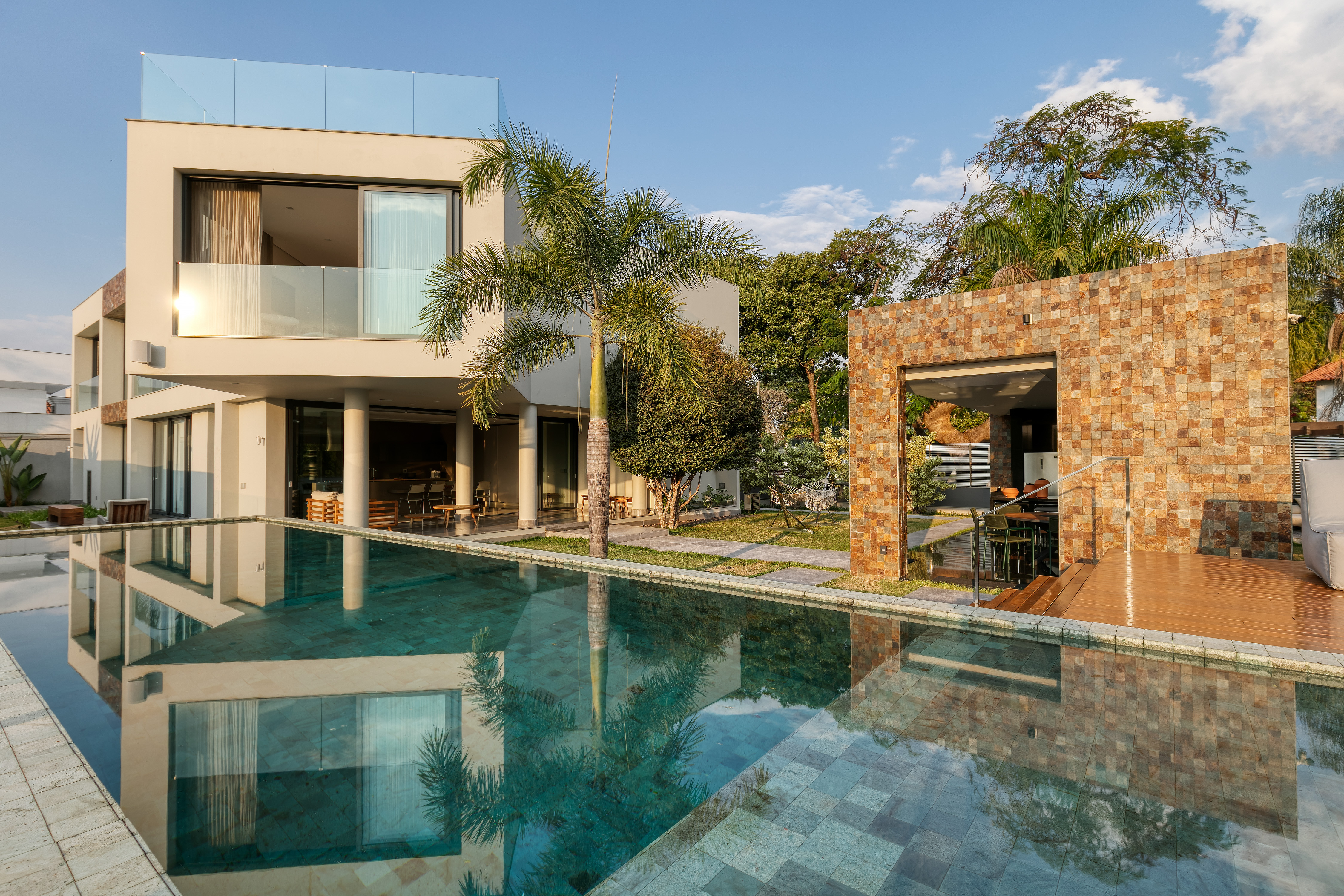 Com vista para a Pampulha, casa de 600 m² é integrada à natureza. Projeto de Lucas Lage. Na foto, jardim com piscina e espaço gourmet.