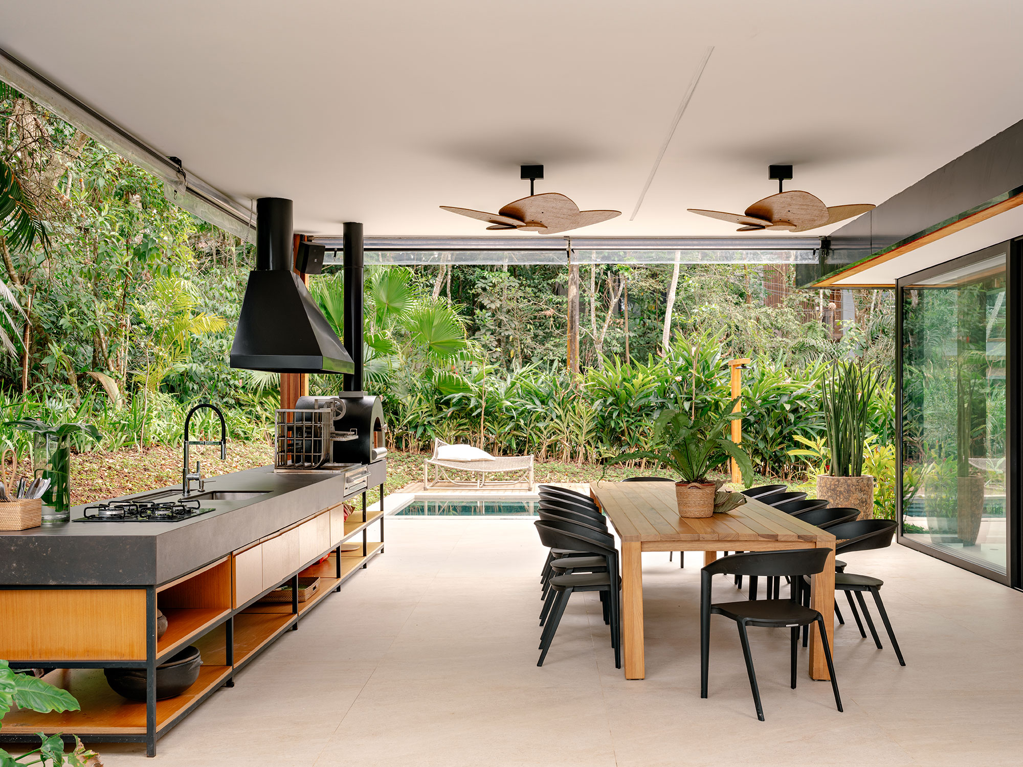 Casa de praia sustentável vira refúgio no meio da Mata Atlântica. Projeto de Patrícia Martinez. Na foto, espaço gourmet com churrasqueira e jardim.