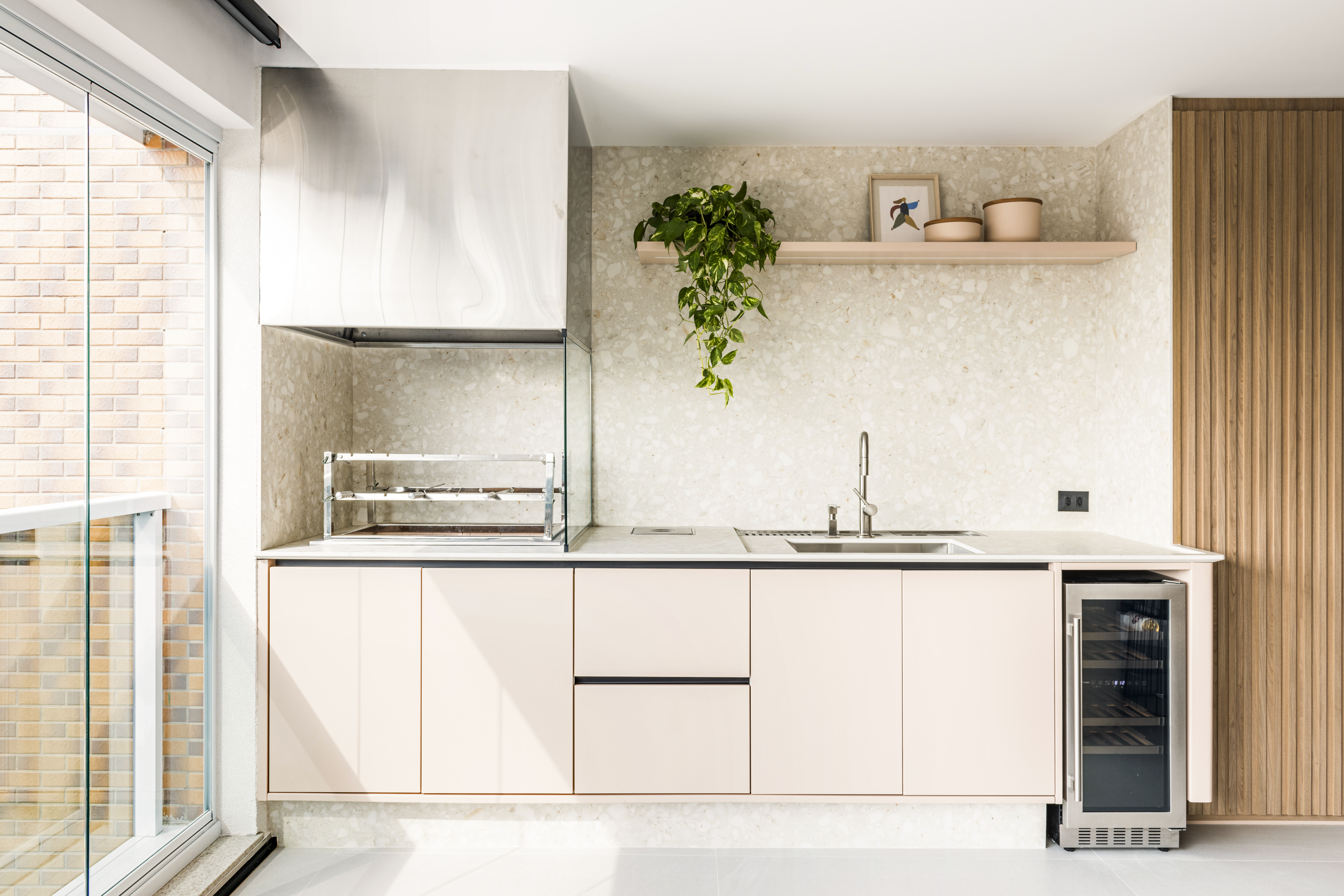 Amarelo mostarda e azul dão personalidade a apartamento de 227 m². Projeto de Tetriz Arquitetura. Na foto, varanda com churrasqueira e marcenaria rosa.