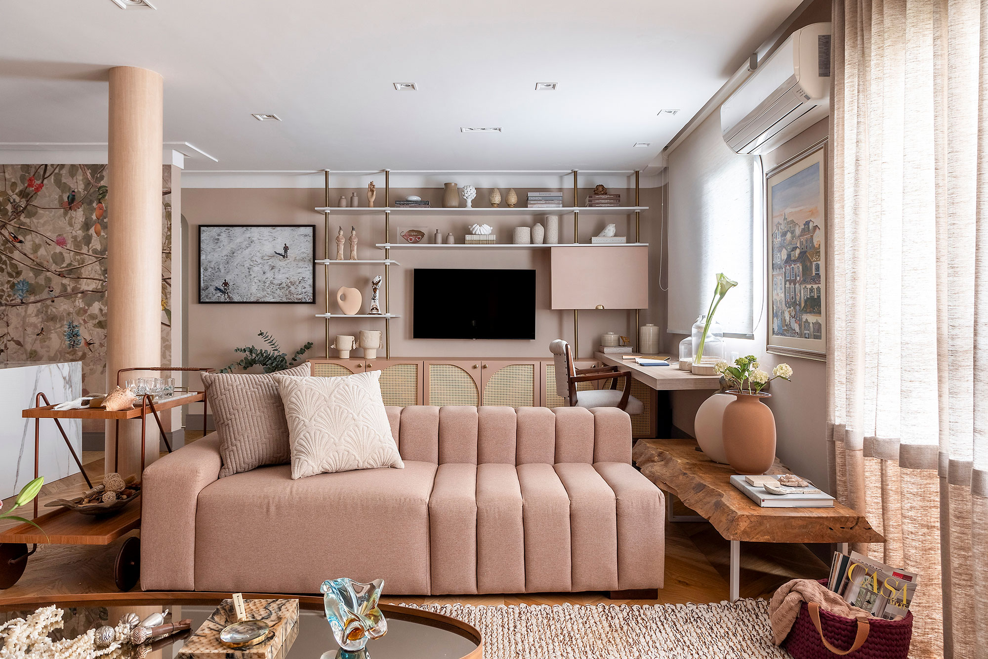 Apartamento une estilos eclético e romântico com toque vintage. Projeto de Larissa Perna. Na foto, sala com sofá rosa e tv.