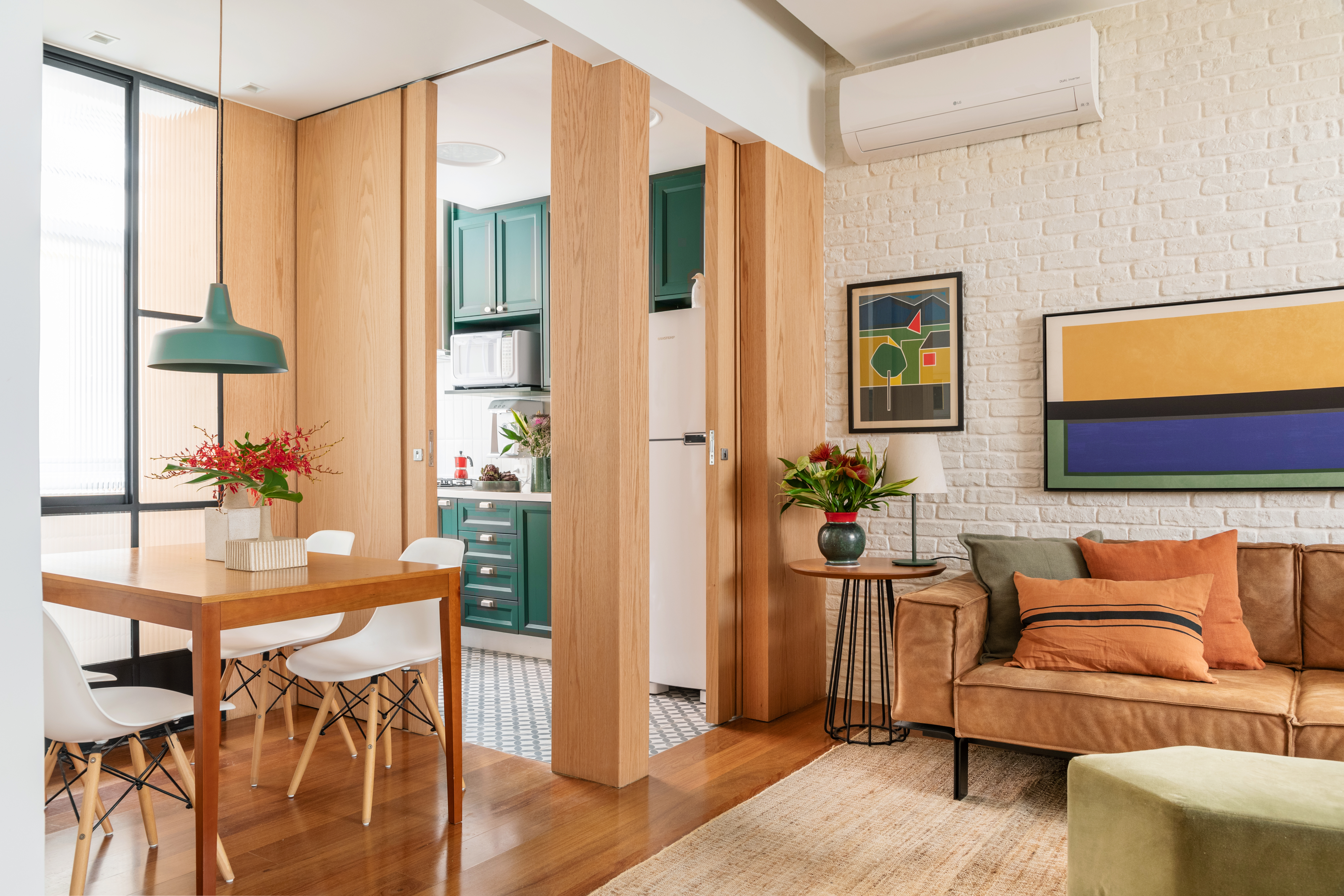 Apartamento térreo de 75 m² ganha cor, charme e muita segurança. Projeto de Paula Neder. Na foto, sala de jantar com vidro canelado. Sala de estar com parede de tijolo.