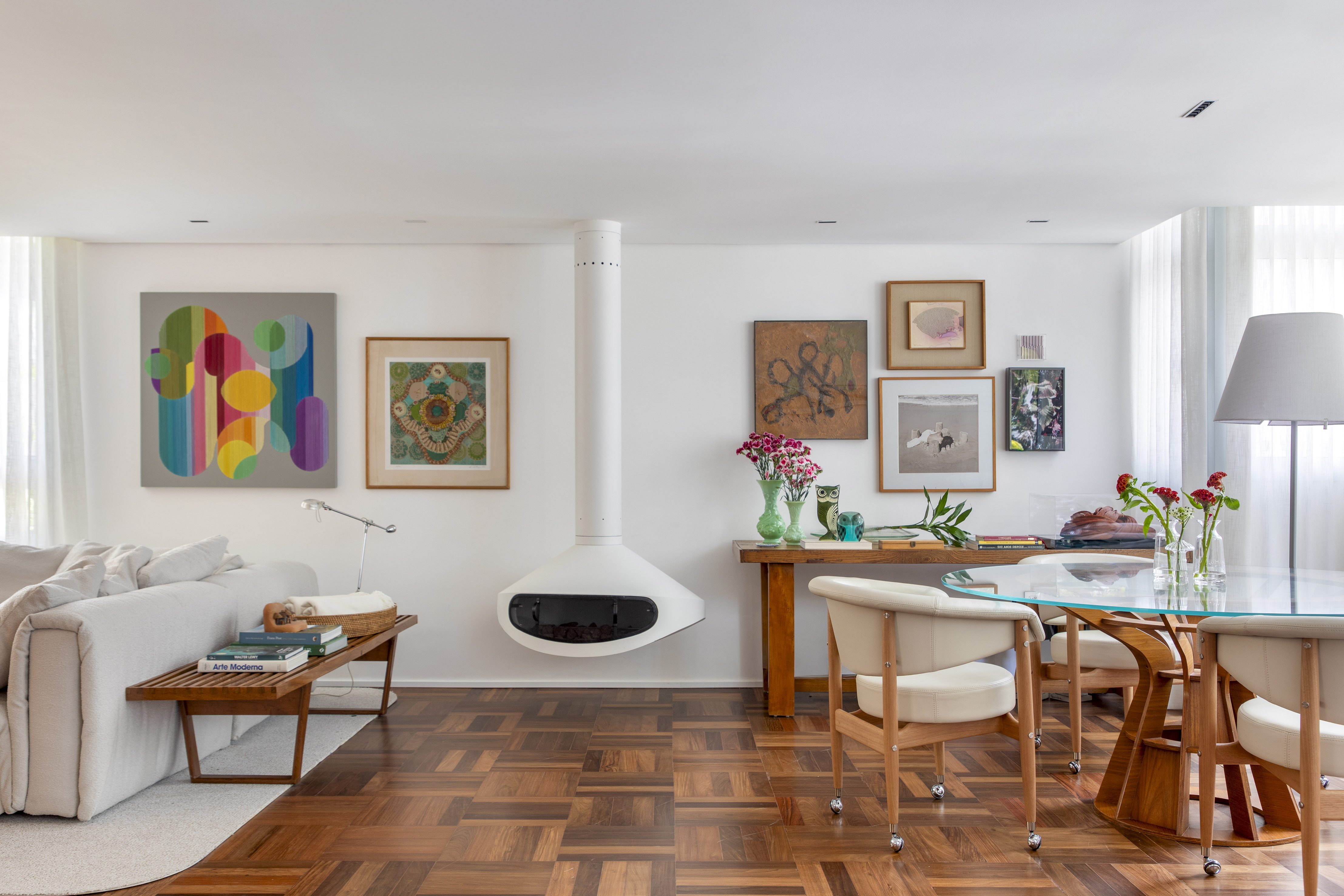 Conheça o novo apartamento da arquiteta Ana Moura em São Paulo. Na foto, sala de estar e jantar com mesa e lareira suspensa.
