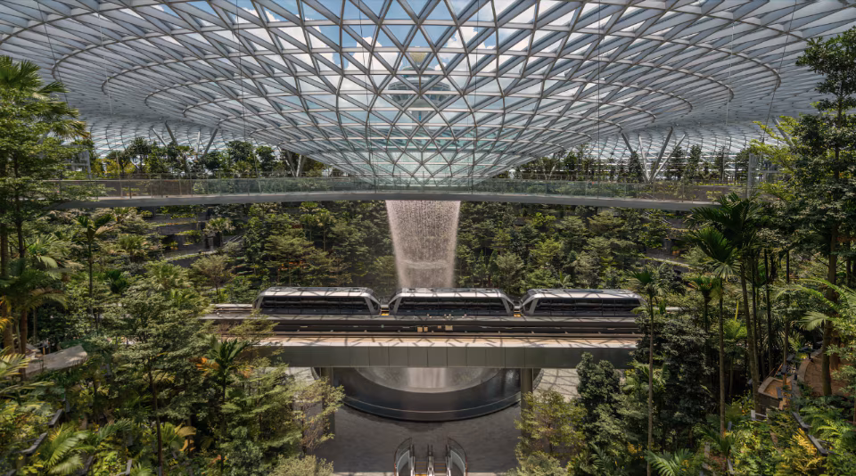 Projetado por Moshe Safdie, o Jewel Changi Airport abriga o Rain Vortex, a maior cachoeira indoor do mundo e um ícone da biofilia aplicada à arquitetura contemporânea.