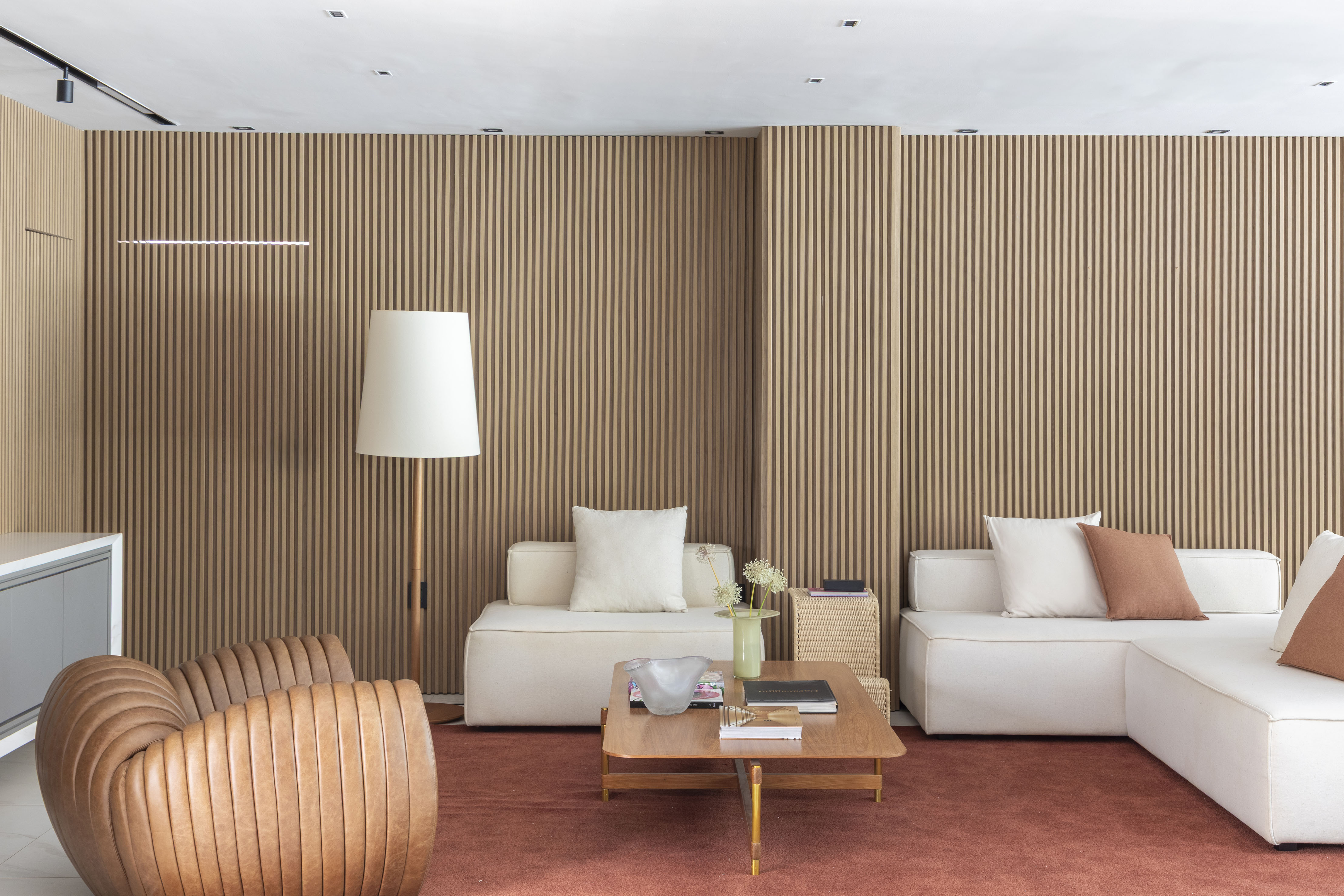 Casa de 1000 m² ganha retrofit completo para abrigar família com trigêmeos. Projeto de Vangii Guerra. Na foto, sala com sofás e parede ripada.
